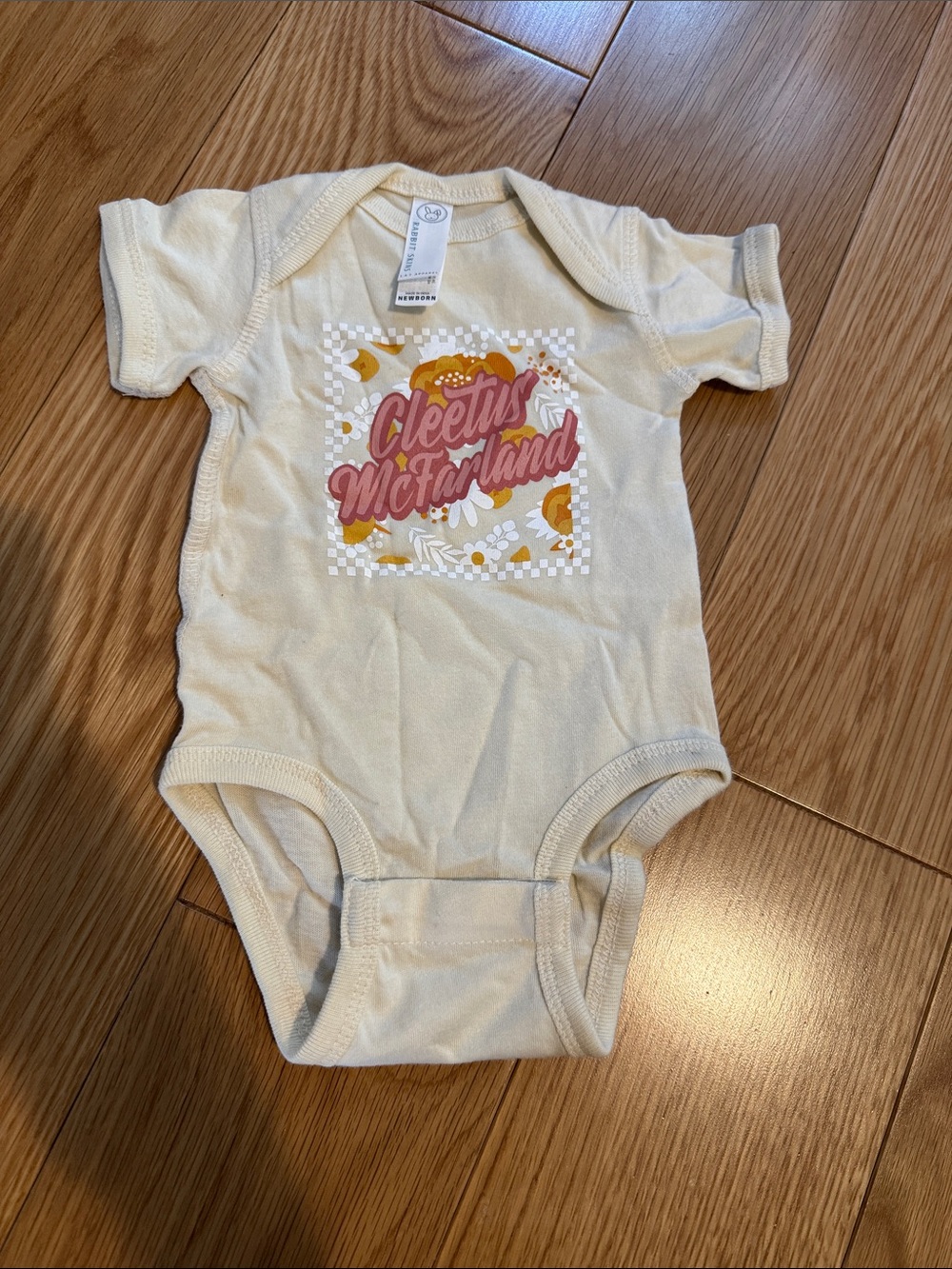 Cleetus McFarland Cream Baby One-Piece with Pink & Orange Graphic